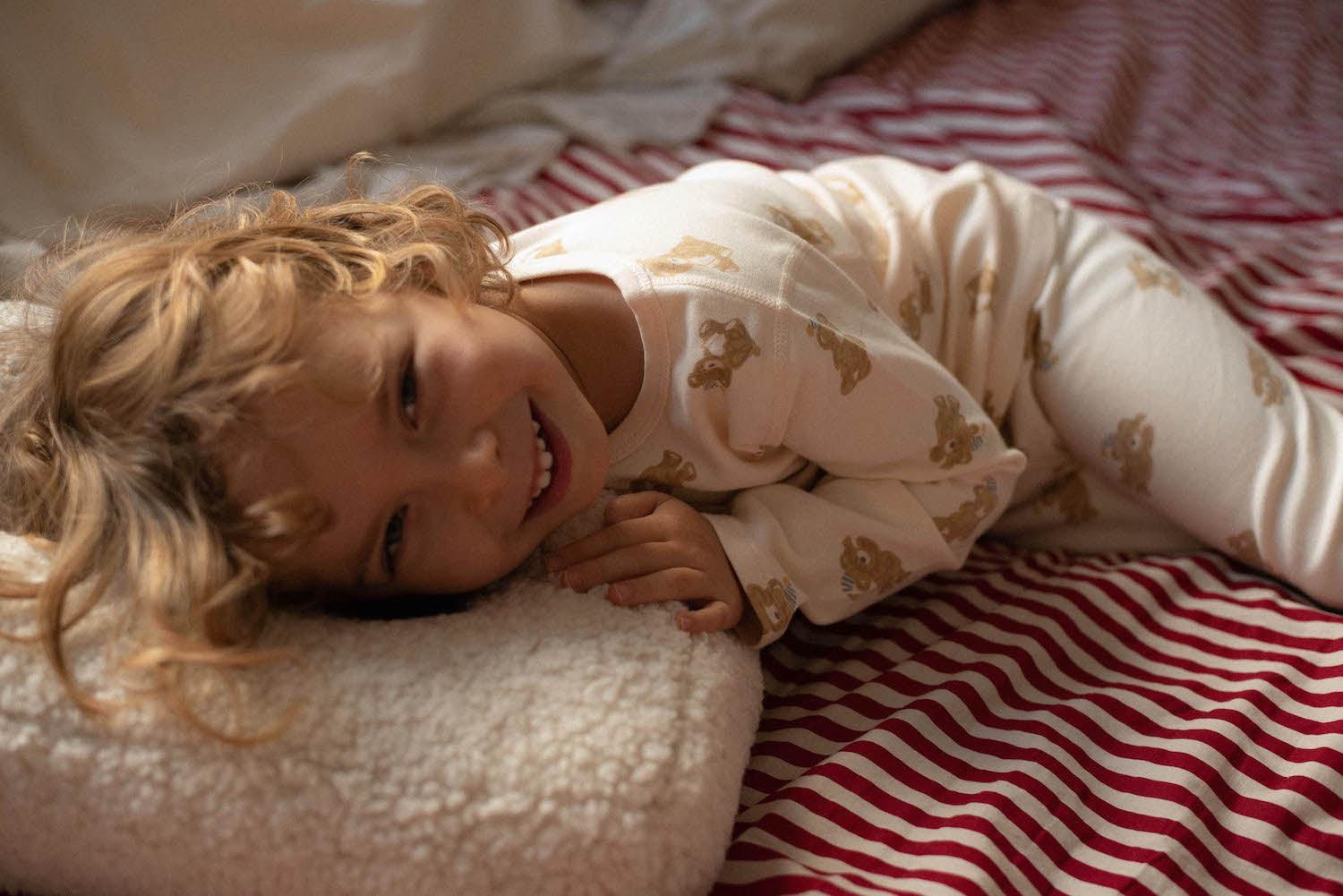 little boy lying on boucle pillow in his bed